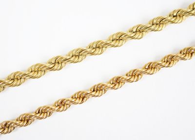 a close up of two gold rope chains on a white surface