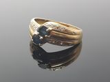 une image d'une bague en or avec une pierre bleue