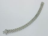 gros plan d'un bracelet en chaîne en argent sur une surface blanche