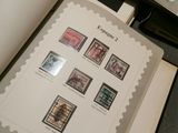an open book with stamps on it sitting on top of a table