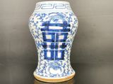 un vase bleu et blanc posé sur une table noire
