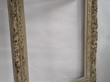 an old picture frame sitting next to a vase on a table