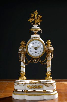 une horloge blanche et dorée posée sur une table en bois