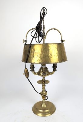une lampe ancienne en laiton avec un abat-jour en laiton sur fond blanc