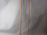 two wooden walking canes sitting next to each other on a gray background