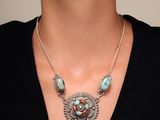 La femme porte un collier orné de perles de turquoise.