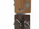 an old wooden box with keys attached to it on a white surface