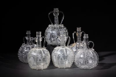 six clear glass vases sitting on top of a black table