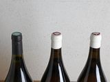 three bottles of wine sitting on a table next to each other