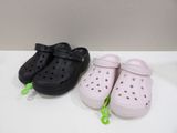 two pairs of crocs are sitting on a white table