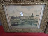 une vieille photo représentant une ville, dans un cadre doré