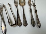 a lot of silver spoons and forks on the table