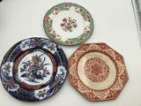 three plates are sitting on a table with flowers and leaves on them