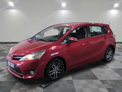 une Toyota Yaris rouge garée dans une pièce au sol à carreaux