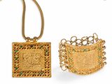 two gold and emerald jewelry pieces, one of which is a pendant and the other of which is a ring