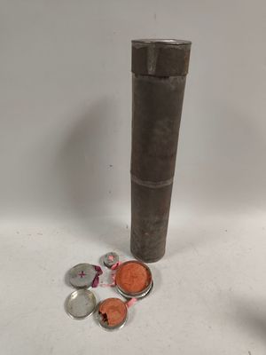 une photo montrant un tube métallique et des pièces de monnaie par terre