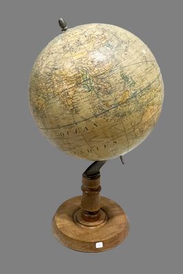 a small globe on a wooden stand with a gray background
