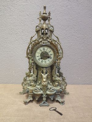 a clock that is sitting on a table with a key in it