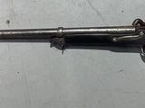 un pistolet posé sur une table, avec un couteau planté en son milieu