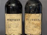 two bottles of wine sitting on a table next to each other