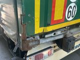 a green and yellow truck that is parked on the side of the road