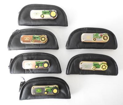 four black leather pencil cases with a green tractor on them