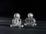 deux figurines en verre représentant des personnes assises sur une table