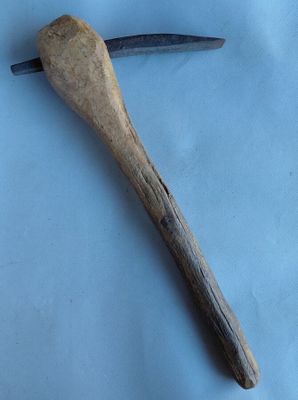 un vieux marteau avec un manche en bois posé sur une surface bleue