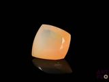 un gros plan d'une pierre d'opalite jaune sur une surface noire