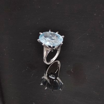 une image d'une bague avec une pierre en topaze bleue