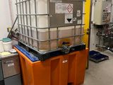 un grand conteneur posé sur une palette dans une pièce