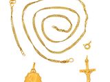 un collier en or et une croix avec une chaîne en or sur fond blanc