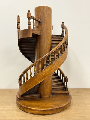 a wooden sculpture of a spiral staircase on a table
