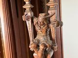 a statue of a man holding a clock on a stand