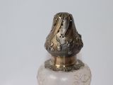a glass bottle with a gold lid on a white surface
