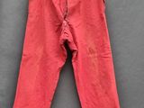 un pantalon rouge suspendu à une corde à linge