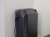 a black phone hanging on the wall next to a potted plant