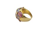 a close up of a gold ring with pink and blue stones