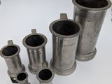 plusieurs types différents de tuyaux métalliques posés sur une surface blanche