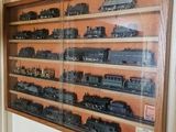 de nombreux trains miniatures exposés dans une vitrine