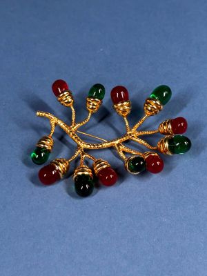 an image of a brooch with red, green, and gold beads
