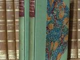 un livre posé sur une étagère, devant une pile de livres