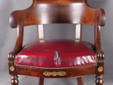 une vieille chaise en bois avec une assise en cuir rouge et des pieds en bois
