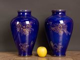 two blue vases sitting next to a lemon on a table