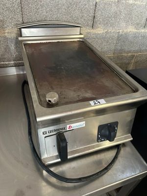 un plan de travail en acier inoxydable surmonté d'une plaque de cuisson