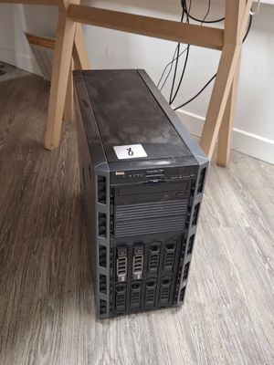 a small black computer on a wooden desk in a room