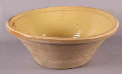 un bol jaune à bord brun posé sur une surface grise