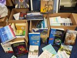 de nombreux livres qui sont rangés dans une boîte posée par terre