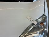 a close up of a white car with a sticker on it
