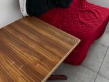 a small table with a red blanket on it next to a red chair